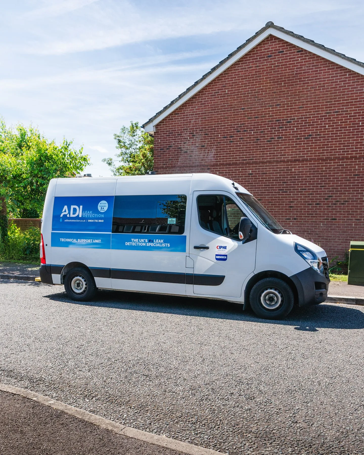 ADI Leak Detection van parked outside a red-brick residential property on a sunny day