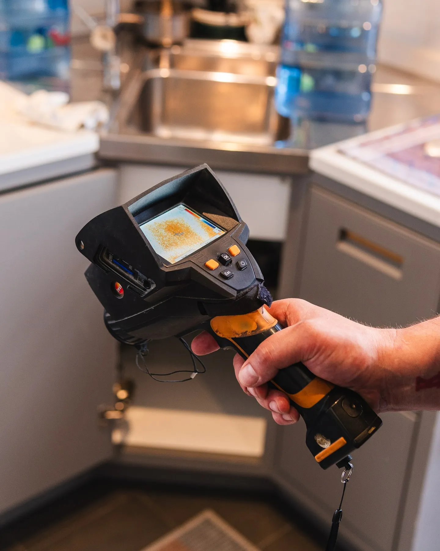ADI engineer checking surface temperatures in a kitchen with a thermal camera